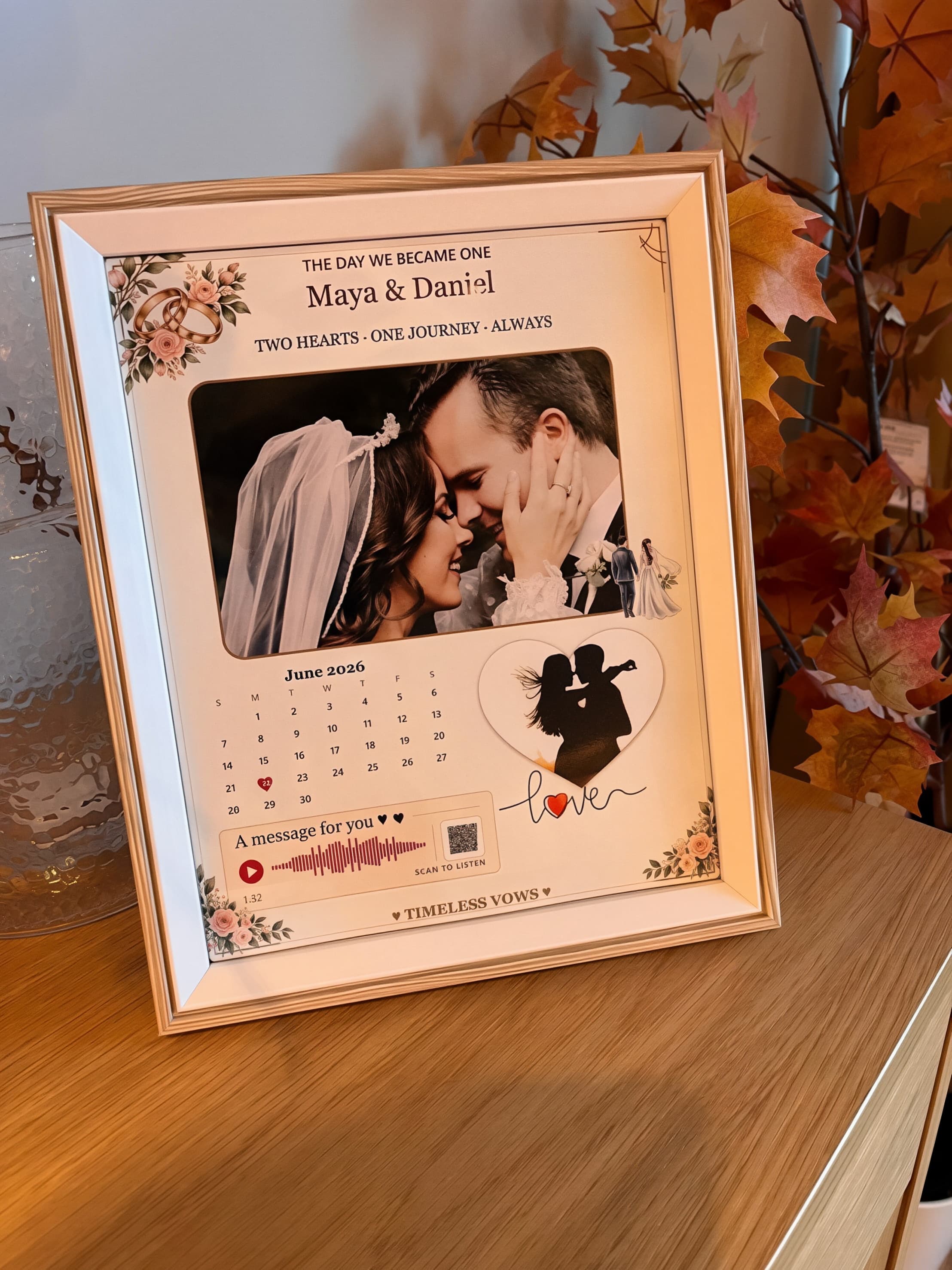 Framed wedding photo print with calendar and QR voice message on a wooden table.