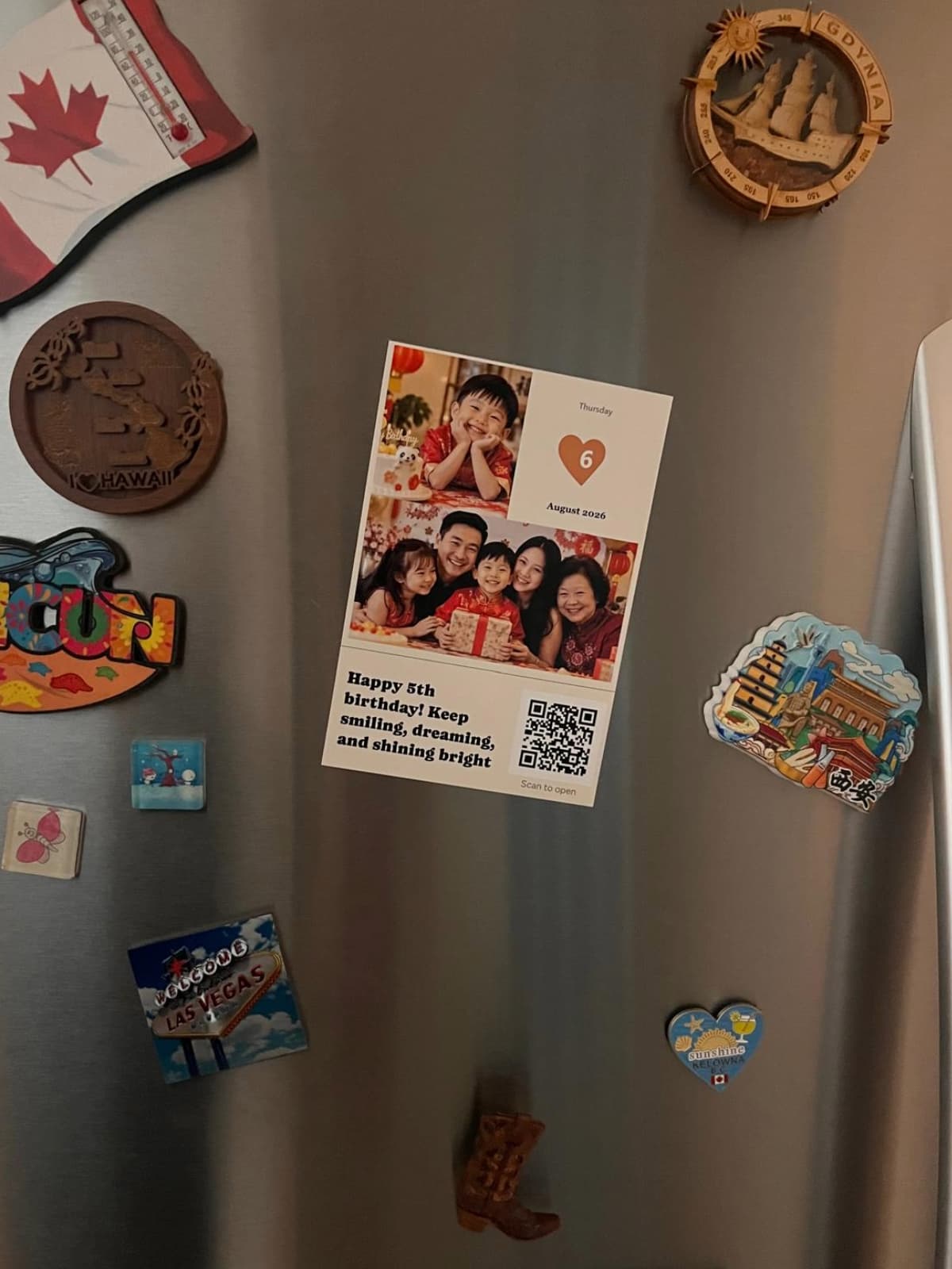 Birthday photo magnet with family photos, a message and QR code on a stainless steel refrigerator.